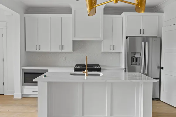 a kitchen with stainless steel appliances white cabinets and a refrigerator