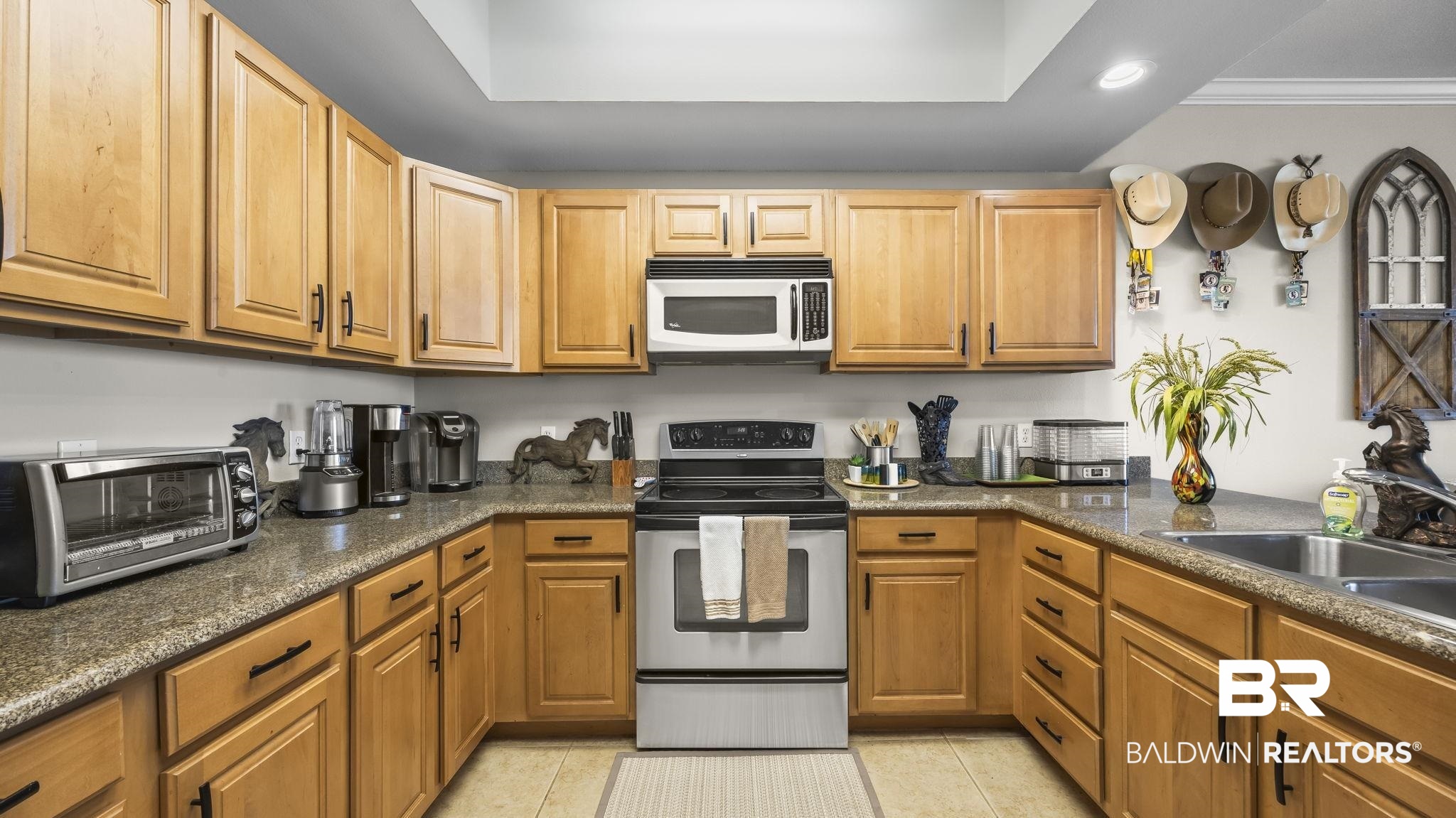 27800 Canal Road, Unit 313 Orange Beach, AL 36561 - Photo 6 of 23 Kitchen featuring stainless steel range with electric cooktop, white microwave, recessed lighting, crown molding, and light tile patterned floors