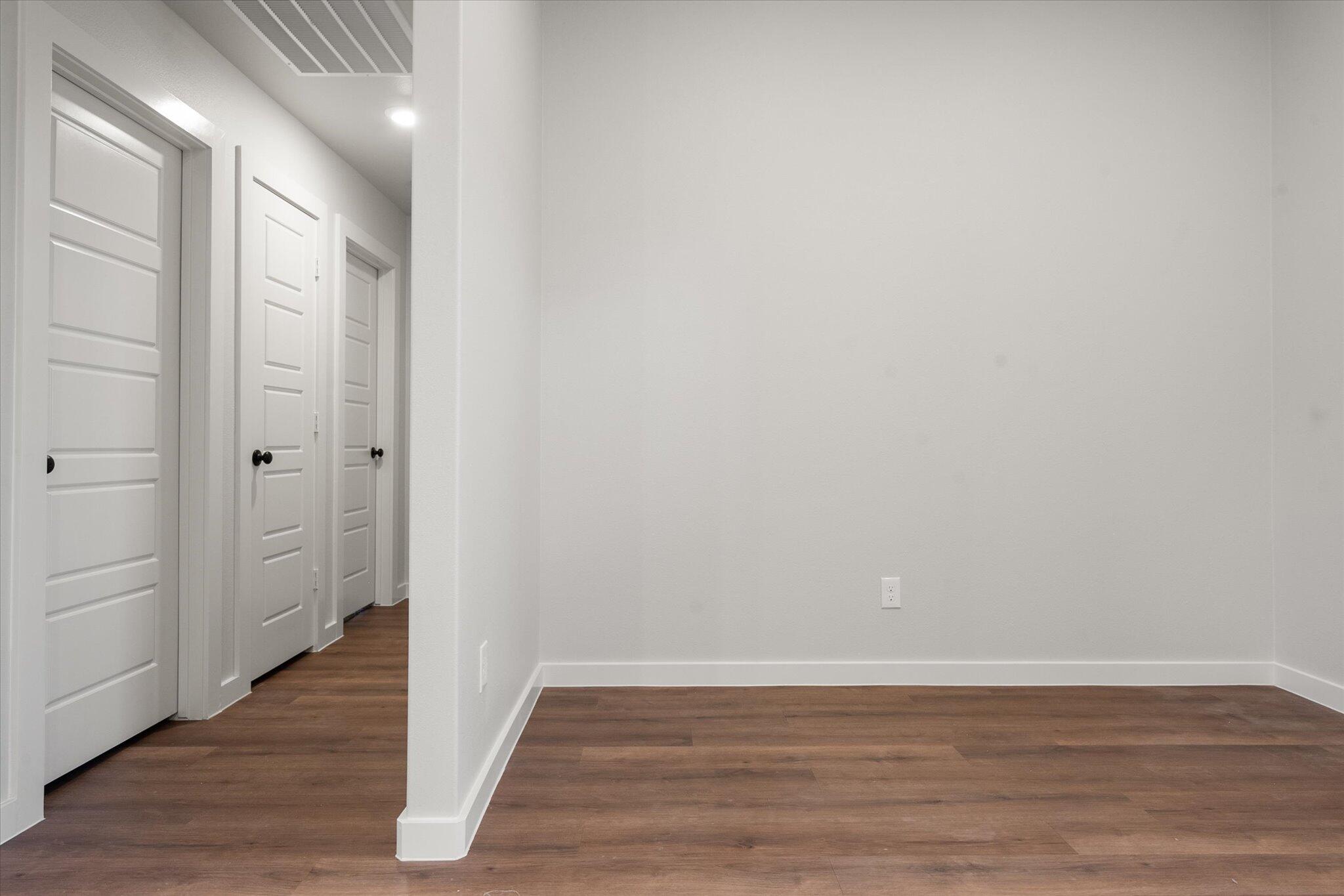 8607 29th Street Lubbock, TX 79407 - Photo 11 of 20 a view of an empty room with wooden floor