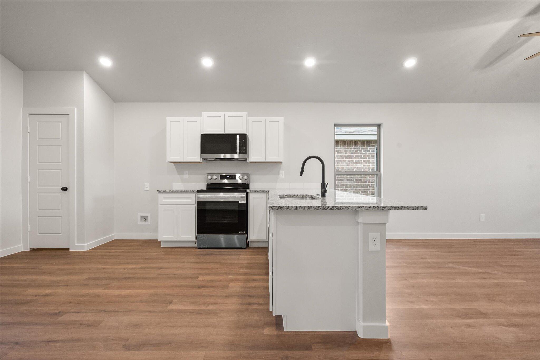 8607 29th Street Lubbock, TX 79407 - Photo 9 of 20 a kitchen with granite countertop a sink cabinets and stainless steel appliances