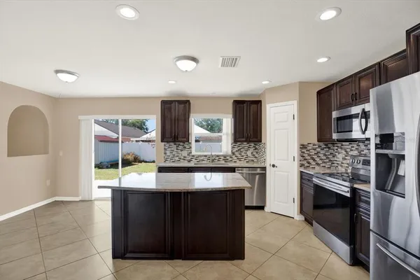 a kitchen with stainless steel appliances granite countertop wooden cabinets and sink