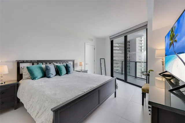 a large bed sitting in a bedroom next to a window