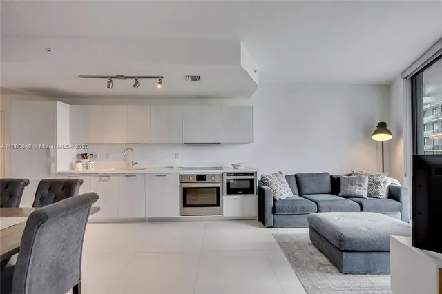 a living room with furniture and kitchen
