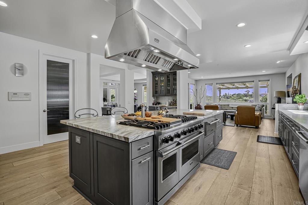 a kitchen with stainless steel appliances granite countertop a stove and a wooden floors
