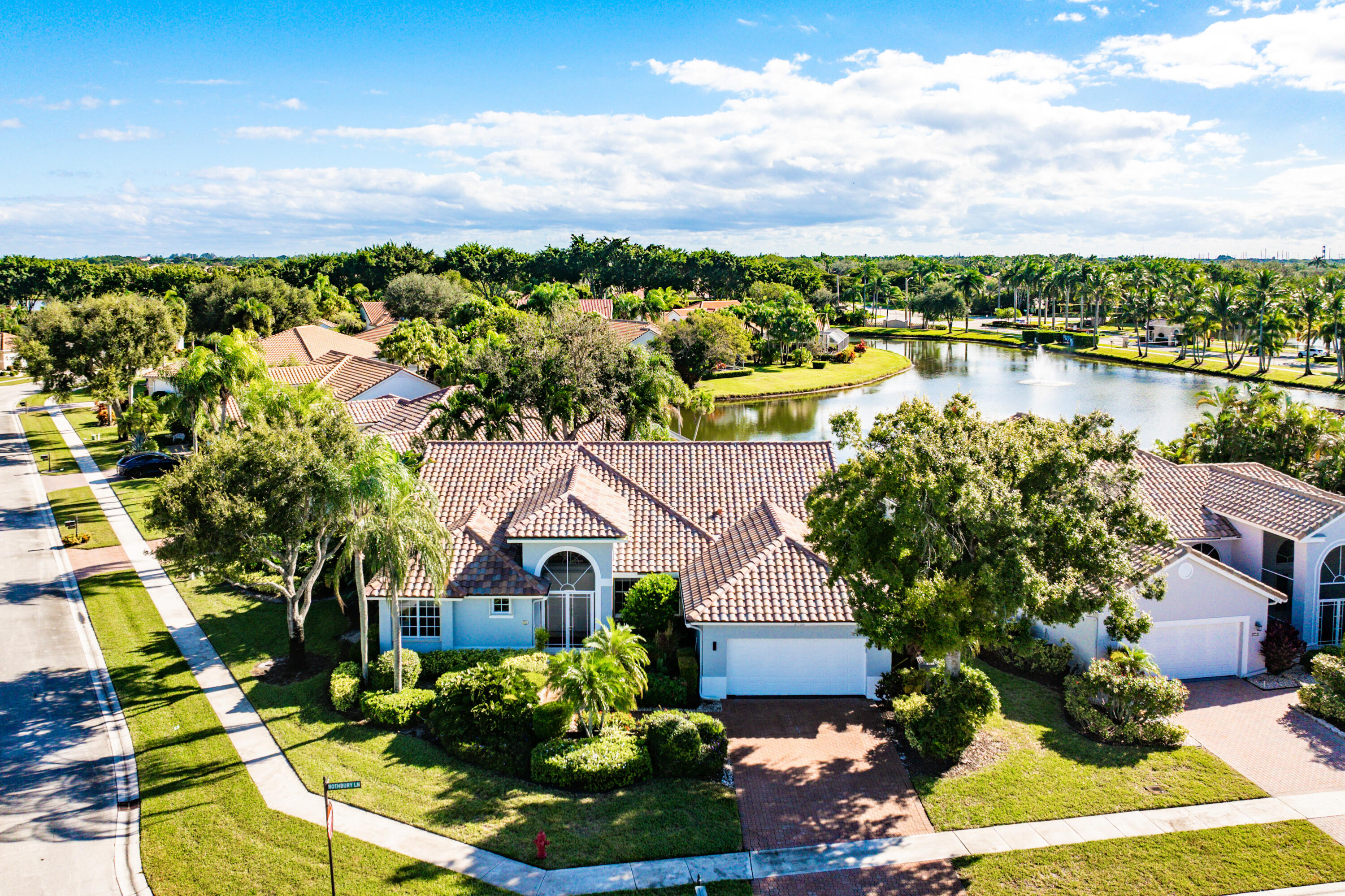a front view of a house with a yard and lake view