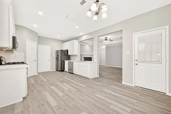 a view of a kitchen with a refrigerator a microwave and a sink