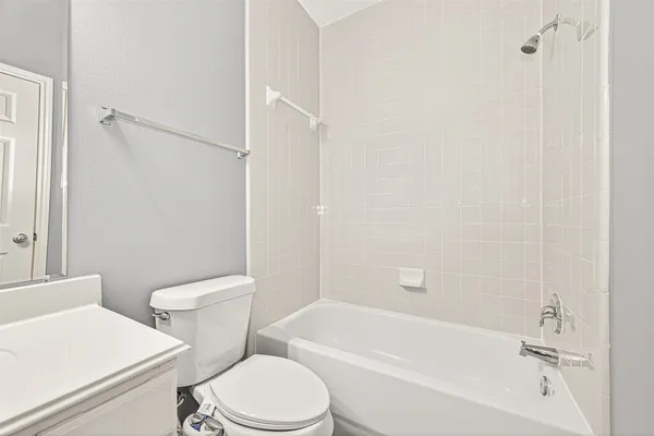 a white toilet sitting next to a bath tub