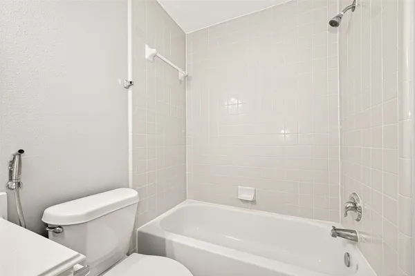 a white toilet sitting next to a bath tub