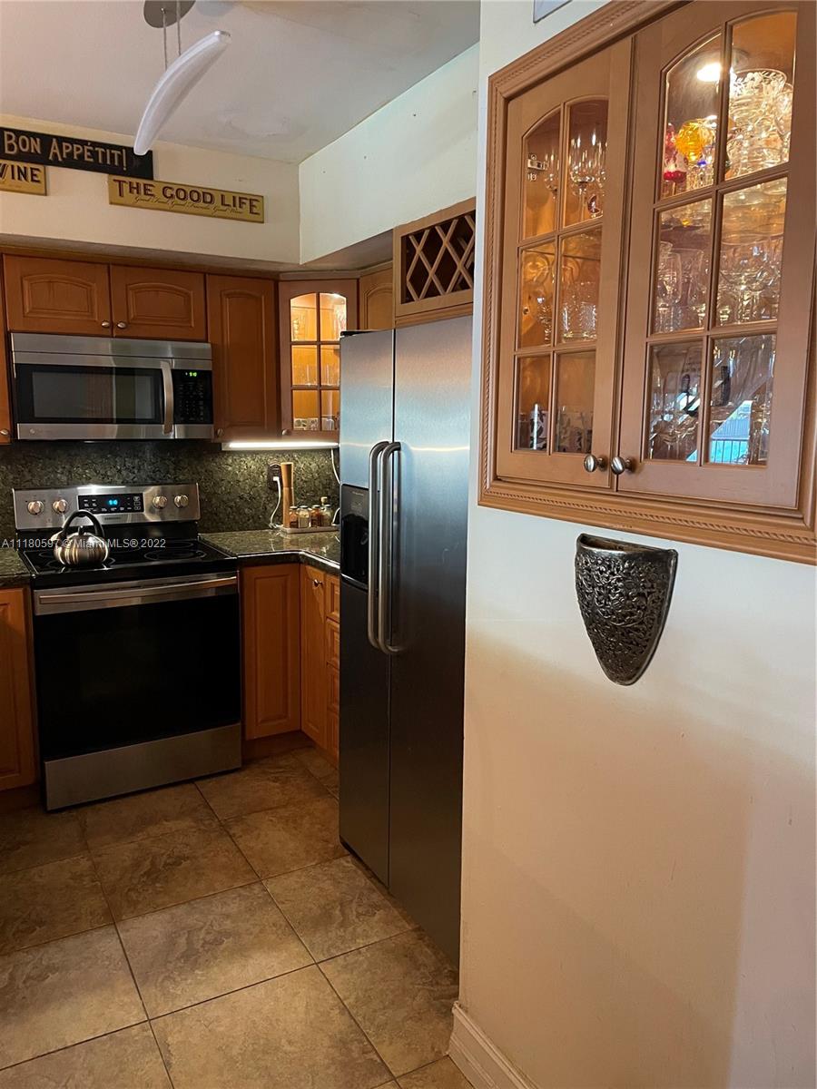 6411 Windmill Gate Road Miami Lakes, FL 33014 - Photo 5 of 23 a kitchen with stainless steel appliances granite countertop a refrigerator a stove a sink and a microwave