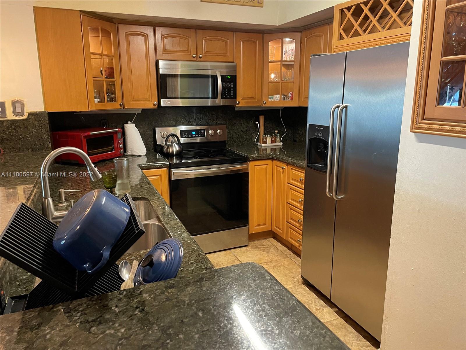 6411 Windmill Gate Road Miami Lakes, FL 33014 - Photo 6 of 23 a kitchen with stainless steel appliances granite countertop a stove a refrigerator and a microwave