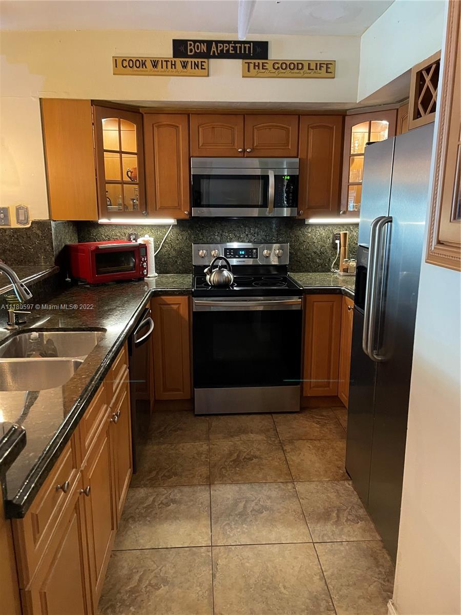 6411 Windmill Gate Road Miami Lakes, FL 33014 - Photo 7 of 23 a kitchen with stainless steel appliances granite countertop a stove a sink and a microwave