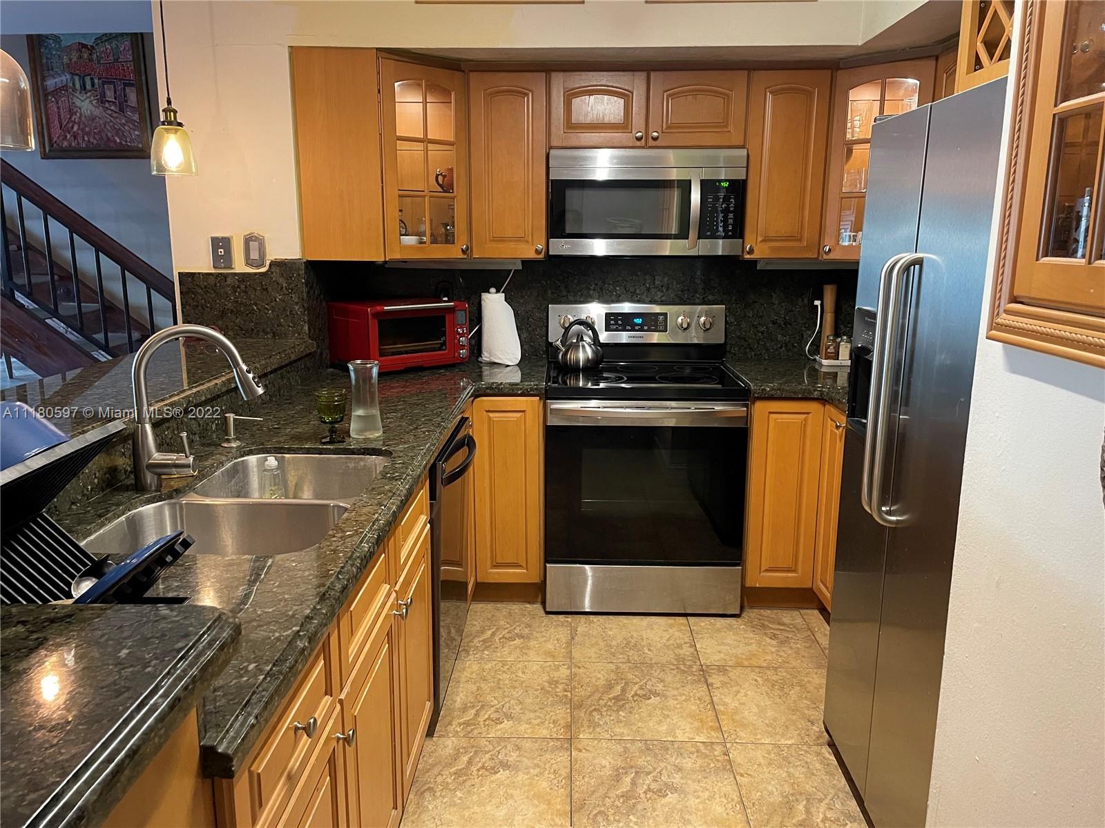 6411 Windmill Gate Road Miami Lakes, FL 33014 - Photo 8 of 23 a kitchen with stainless steel appliances granite countertop a sink stove and refrigerator