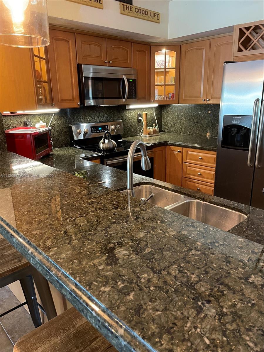 6411 Windmill Gate Road Miami Lakes, FL 33014 - Photo 9 of 23 a kitchen with stainless steel appliances granite countertop a sink stove and granite counter top