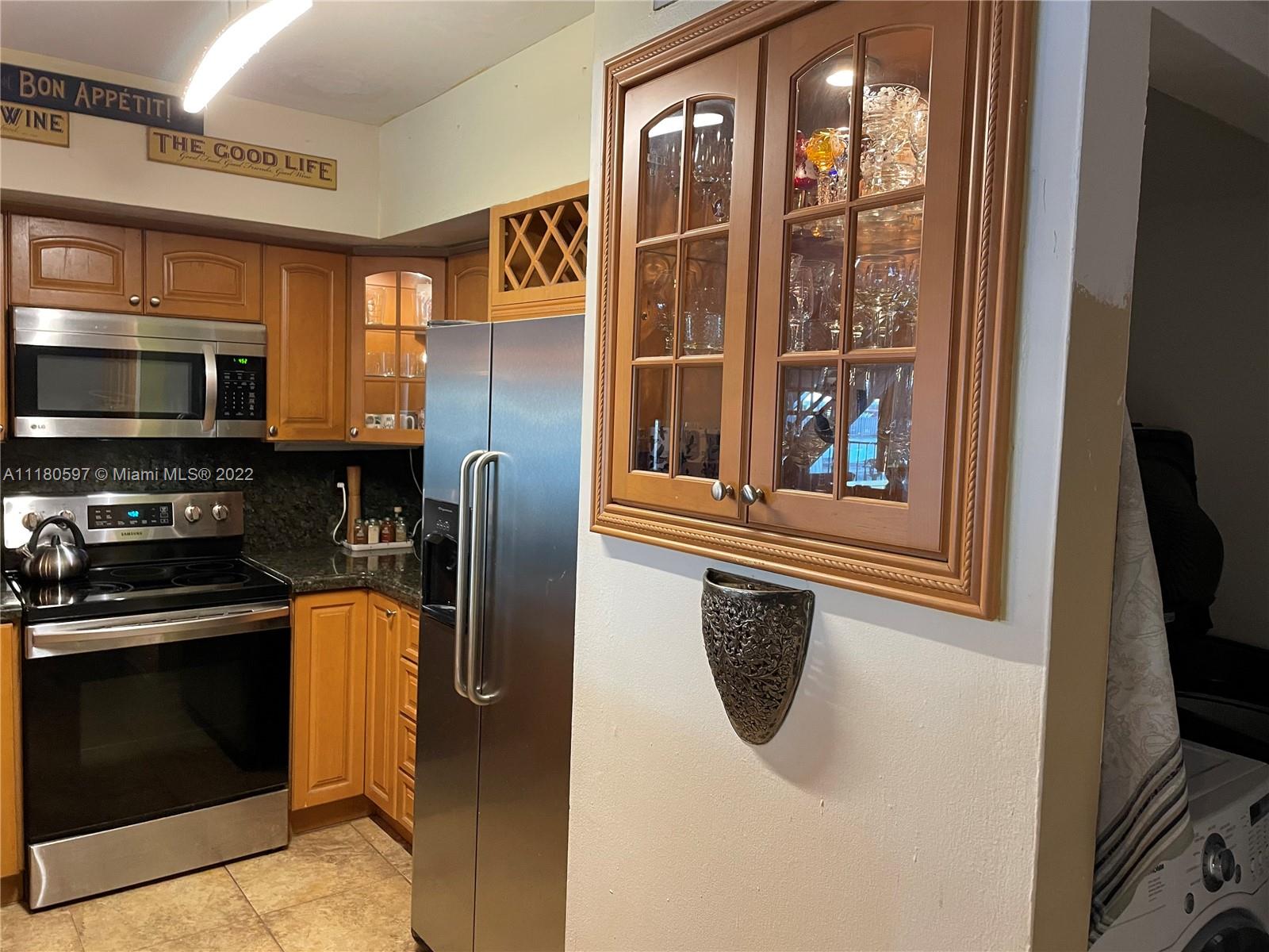6411 Windmill Gate Road Miami Lakes, FL 33014 - Photo 10 of 23 a kitchen with stainless steel appliances granite countertop a refrigerator and a stove top oven