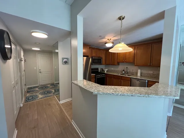 a kitchen with stainless steel appliances granite countertop a sink a stove and a refrigerator