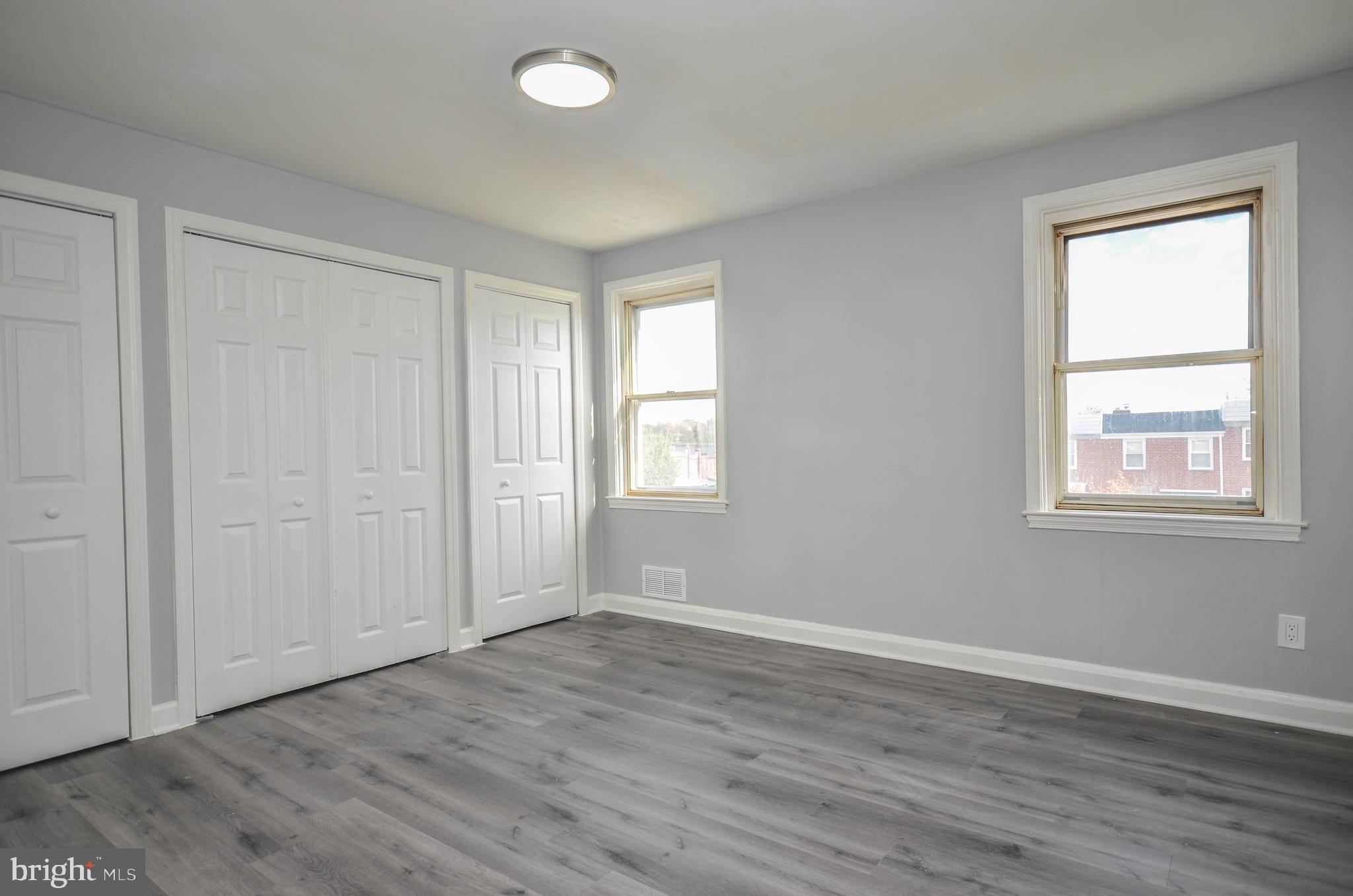 3917 Dudley Avenue Baltimore, MD 21213 - Photo 11 of 23 an empty room with wooden floor and windows