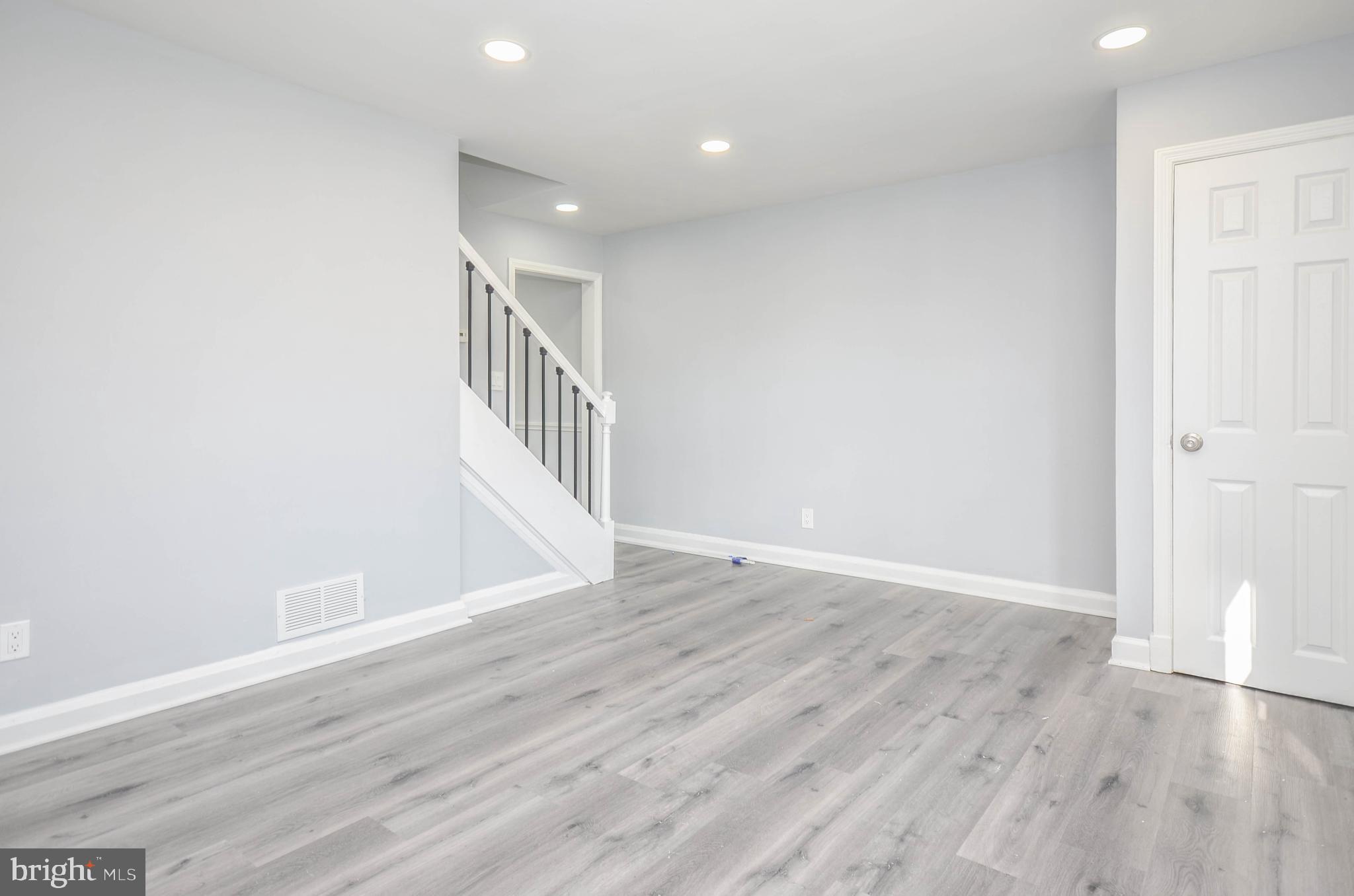 3917 Dudley Avenue Baltimore, MD 21213 - Photo 3 of 23 a view of an empty room with wooden floor and entryway