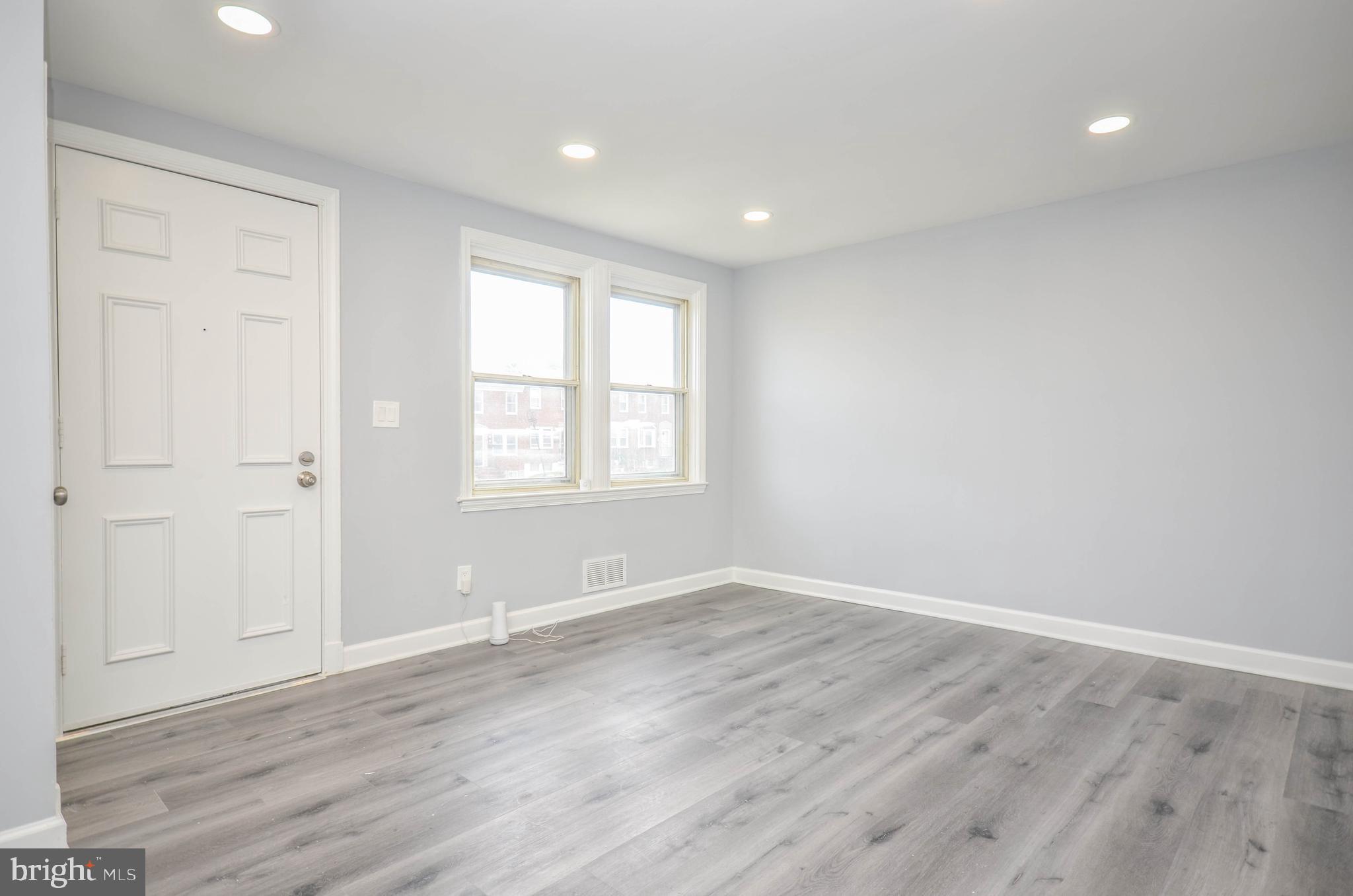 3917 Dudley Avenue Baltimore, MD 21213 - Photo 5 of 23 wooden floor in an empty room with a window