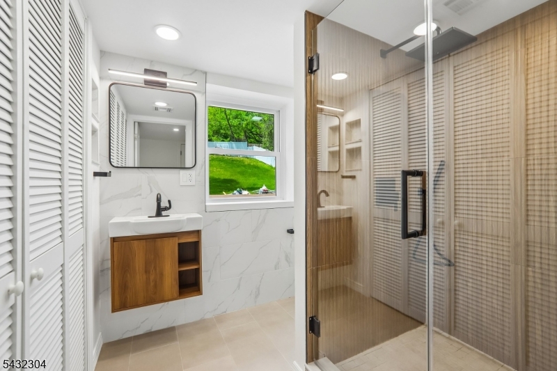 34 Clark Street Summit, NJ 07901 - Photo 28 of 36 a bathroom with a bathtub sink and mirror
