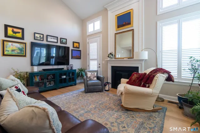 a living room with furniture a flat screen tv and a fireplace