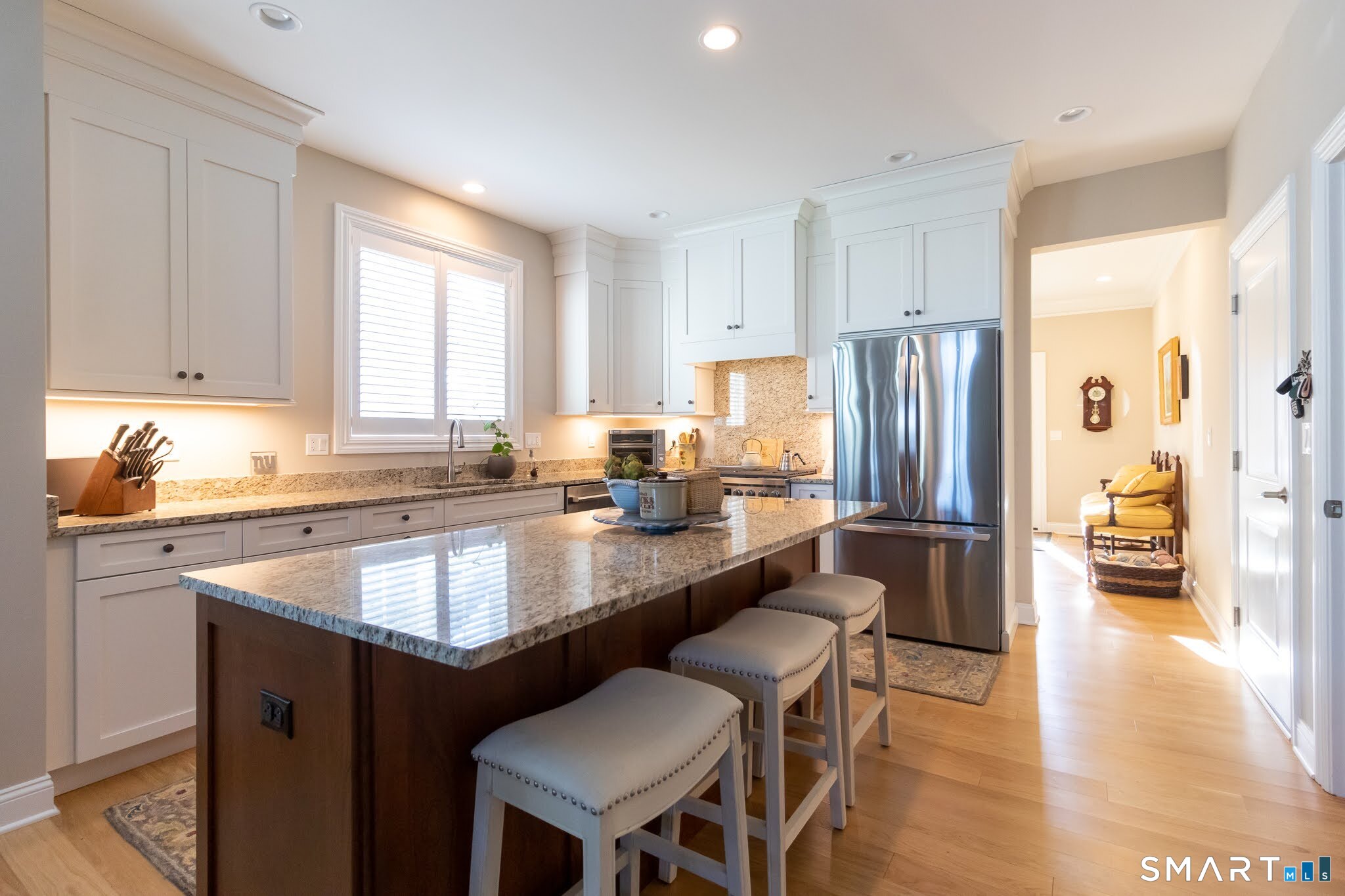 22 Soderman Way Cheshire, CT 06410 - Photo 5 of 40 a kitchen with granite countertop white cabinets a refrigerator a stove a dining table and chairs