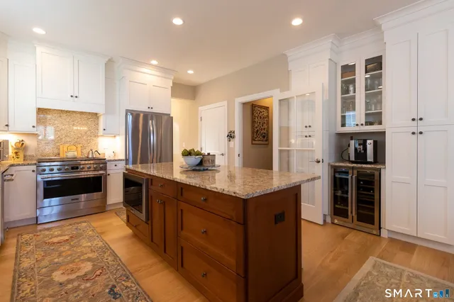 a kitchen with stainless steel appliances granite countertop a stove refrigerator and cabinets