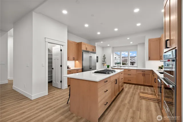a large kitchen with stainless steel appliances granite countertop a large center island and a sink