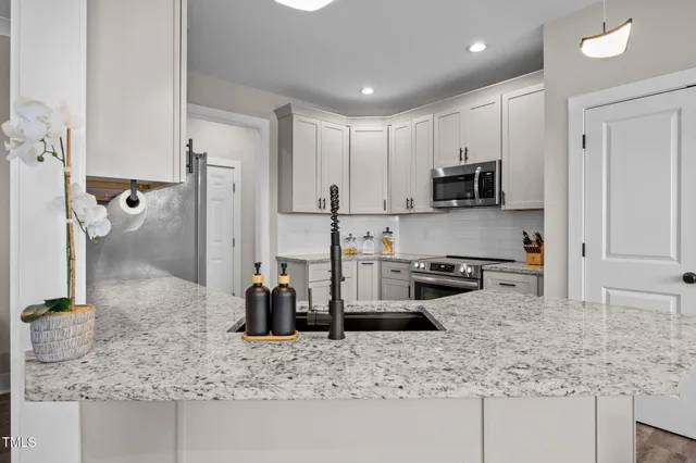 a kitchen with stainless steel appliances granite countertop a refrigerator and a stove top oven