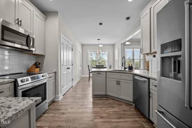 a kitchen with granite countertop white cabinets and stainless steel appliances