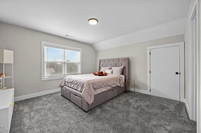 a bedroom with a bed and a refrigerator