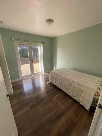 a bedroom with a bed and wooden floor
