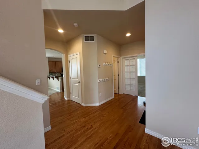 a view of a hallway with wooden floor and closet