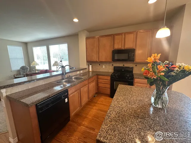 a kitchen with stainless steel appliances granite countertop a sink a refrigerator and a granite counter tops