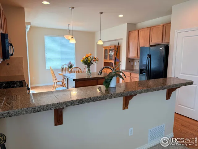 a kitchen with a stove a sink a microwave a dining table and chairs