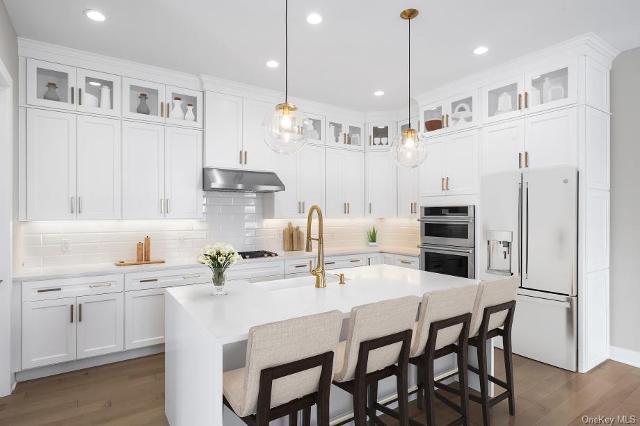 a kitchen with stainless steel appliances kitchen island granite countertop a kitchen island and chairs in it