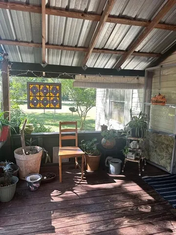a view of a porch with furniture and a yard