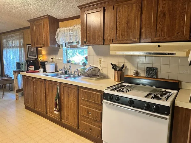 a kitchen with stainless steel appliances a stove a sink and cabinets
