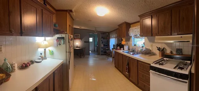 a kitchen with sink stove and cabinets