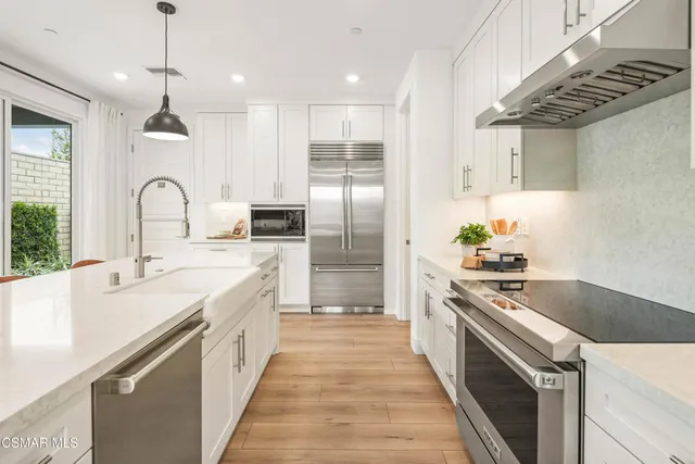 a kitchen with stainless steel appliances granite countertop a sink and refrigerator