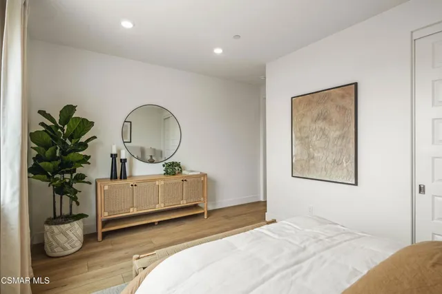 a bedroom with bed and a potted plant