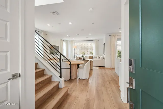 a view of entryway and kitchen with wooden floor