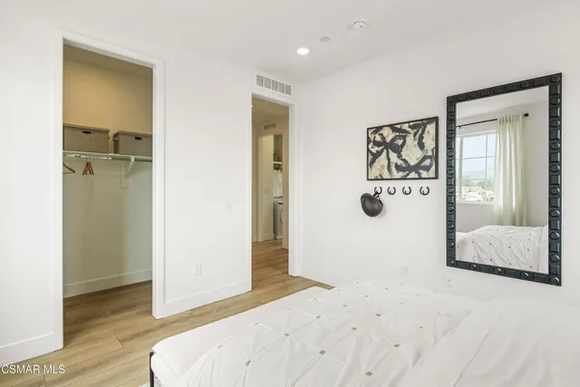 a bedroom with a bed and wooden floor