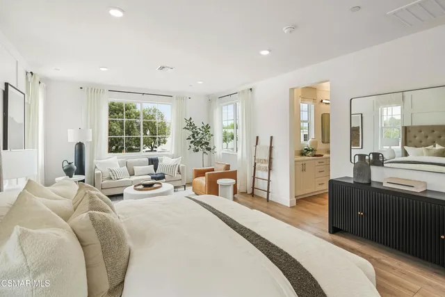 a large bedroom with bed and large windows