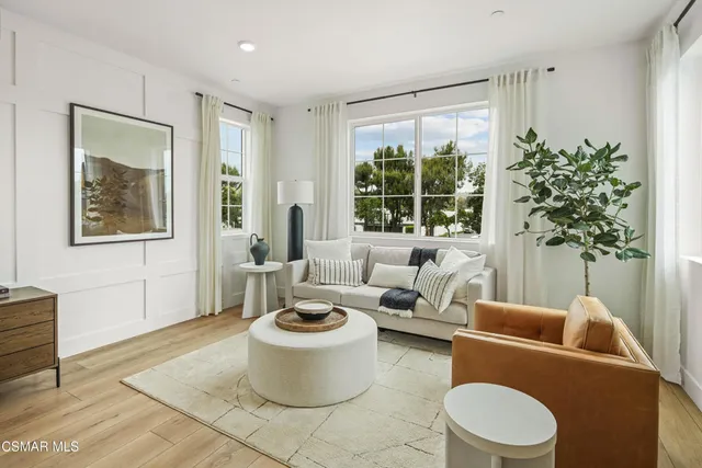 a living room with furniture a window and a potted plant