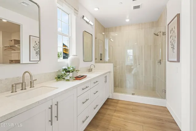 a bathroom with a double vanity sink mirror double and shower