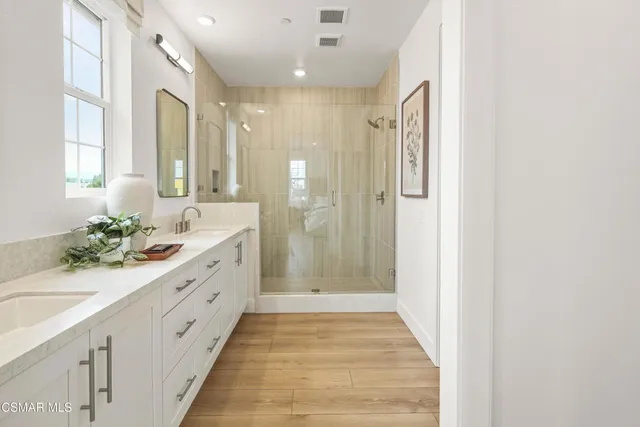 a spacious bathroom with a double vanity sink shower and a mirror
