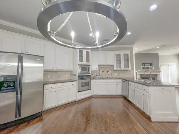 a large kitchen with kitchen island granite countertop lots of white stainless steel appliances lots of counter top space and stainless steel appliances
