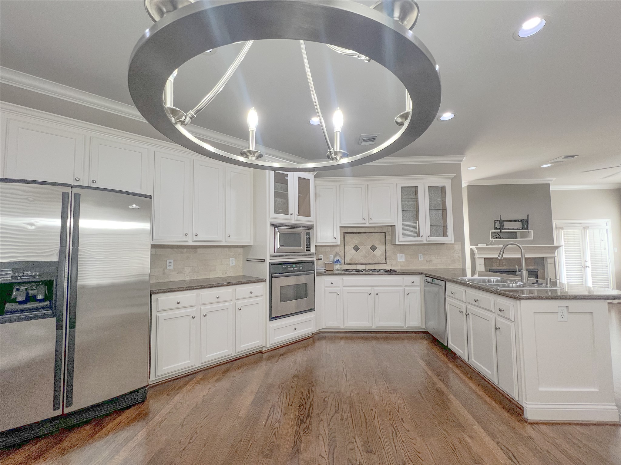 a large kitchen with kitchen island granite countertop lots of white stainless steel appliances lots of counter top space and stainless steel appliances