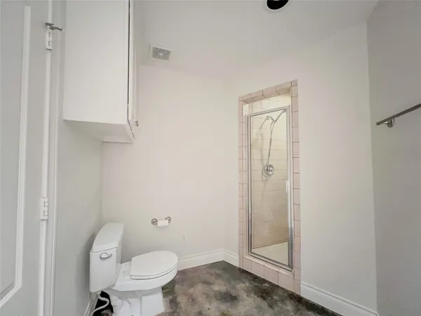 a bathroom with a granite countertop toilet and a sink
