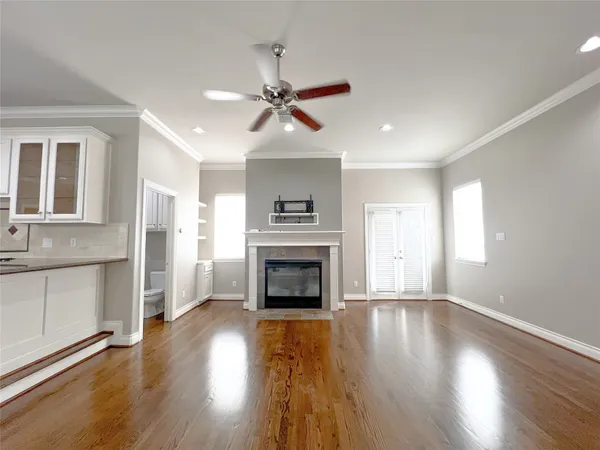 a living room with stainless steel appliances wooden floor and a window